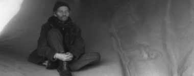 Gary Cramer seated in a cave, still from the short film "The Moment"